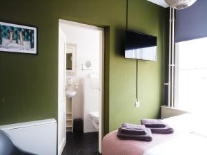 a bedroom with green walls and a bed with purple towels at Boutique Lodge Zandvoort in Zandvoort +88 photos