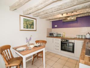 a kitchen with a small table and chairs in a kitchen at Kooky Cottage in Brecon