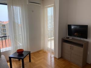 a living room with a flat screen tv and a table at Apartment Iva in Boreti