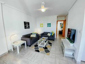 sala de estar con sofá y mesa en Stunning 2 bedroom apartment with Pool View, en Alicante