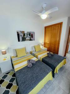 1 dormitorio con 2 camas y ventilador de techo en Stunning 2 bedroom apartment with Pool View, en Alicante