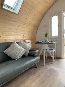 a living room with a couch and a table at Glastonbury Glamping in Wells