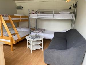 een woonkamer met 2 stapelbedden en een bank bij Gårdshus i Borgholm, Öland in Borgholm