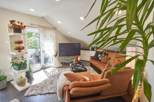 ein Wohnzimmer mit einem Sofa und einem TV in der Unterkunft Ferienwohnung Bodensee in Raderach in Friedrichshafen