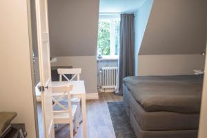 een slaapkamer met een bed, een tafel en een stoel bij Continental Apartment Hotel Helsingborg in Helsingborg