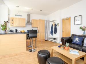 a living room and kitchen with a couch and a table at Gwel Y Mor in Pwllheli +17 photos