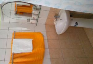 a bathroom with an orange bench and a toilet at Room in Studio - Rock Garden Apartment by the beach in Pefki