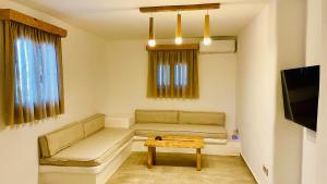 un soggiorno con divano e tavolo di Aeris suites pori semi basement villa a Koufonisia