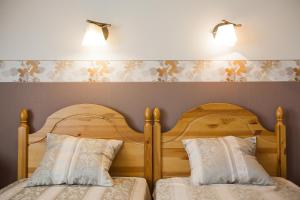 two beds in a bedroom with two lights on the wall at Liepas in Ventspils