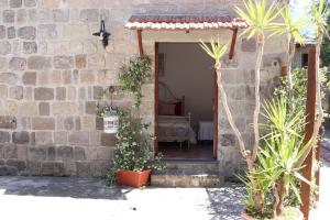 un bâtiment en pierre avec une porte et des plantes devant lui dans l'établissement Emy's Country House, à Castellammare di Stabia