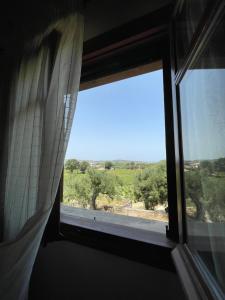 ザキントスにあるSerenita Villaの野原の景色を望む部屋の窓