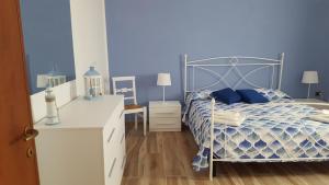 una camera da letto blu con un letto e una scrivania di VILLA MANUELA a Punta Prosciutto
