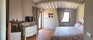 a bedroom with a bed and a tv and a dresser at Poggio ai Gelsi in Pienza +92 photos