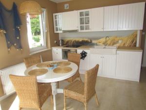 a kitchen with a table and chairs and a sink at Apartament Korab in Żarnowska