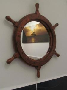 a wooden mirror on a wall with a ship in it at Apartament Korab in Żarnowska +8 photos
