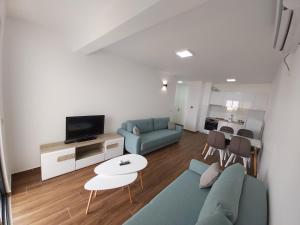 a living room with a blue couch and a tv at Apartmani Aida in Dobra Voda