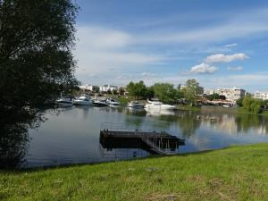 a dock on a river with boats in the water at Napsugár Szálló Baja in Baja