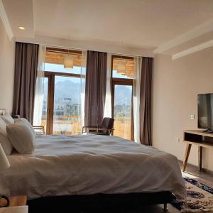 a bedroom with a large bed and a television at Hotel Amanthi Ladakh in Leh