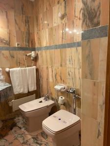y baño con aseo y lavamanos. en Hotel II Virrey en El Burgo de Osma