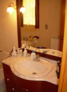 y baño con lavabo y espejo. en Ariedo Bed And Breakfast en Capoterra