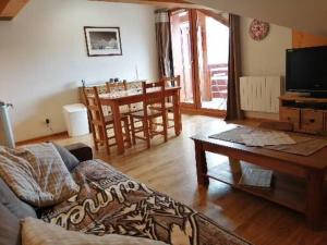 a living room with a couch and a table at Appartement Valmeinier 4 à 5 personnes Résidence LAGRANGE in Valmeinier
