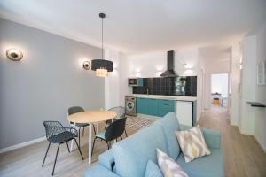 ein Wohnzimmer mit einem blauen Sofa und einem Tisch in der Unterkunft Apartamentos Líbere Valencia Abastos in Valencia