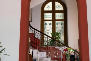 a spiral staircase with a stained glass window at Hotel Tonic in Palermo