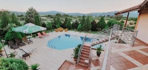 uma vista superior para uma piscina com cadeiras e um guarda-sol em Villa Katerina & Pool em Gevgelija