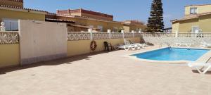 a patio with a swimming pool next to a building at Casa Verde in Caleta De Fuste