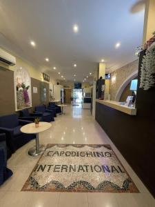 a lobby with a waiting area with a rug on the floor at Capodichino International Hotel in Naples