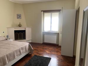 Schlafzimmer mit einem Bett, einem Kamin und einem Fenster in der Unterkunft Vittoria in Celano