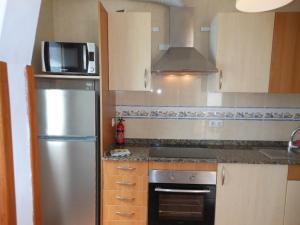 a kitchen with a stainless steel refrigerator and a microwave at Casa Verde in Caleta De Fuste