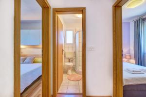 a mirror in a bedroom with a bed and a bathroom at SVEN in Veli Lošinj
