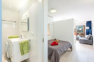 a bathroom with a sink and a bed in a room at Tenerife South Apartments in Playa de las Americas