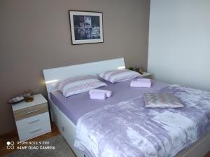 Un dormitorio con una cama con sábanas y almohadas púrpuras. en Apartment Iris Split en Split