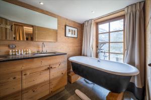 łazienka z dużą wanną i umywalką w obiekcie Madame Vacances Chalet Davos w mieście Val dʼIsère