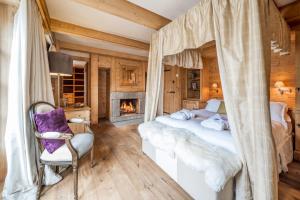 sypialnia z łóżkiem z baldachimem i kominkiem w obiekcie Madame Vacances Chalet Davos w mieście Val dʼIsère