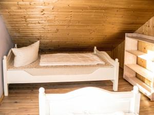 a bed in a room with a wooden wall at Ferienhaus Strandrubin in Baabe