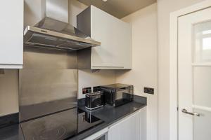 a kitchen with a microwave and a stove top oven at The Rose Street Apartment in Edinburgh
