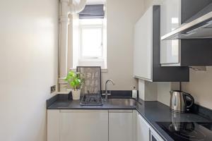 エディンバラにあるThe Rose Street Apartmentの白いキャビネット、シンク、窓付きのキッチン +11枚の写真