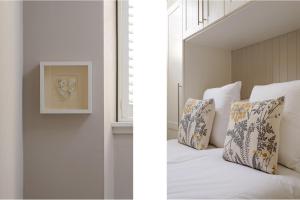 1 dormitorio con cama con almohadas y ventana en The Rose Street Apartment, en Edimburgo