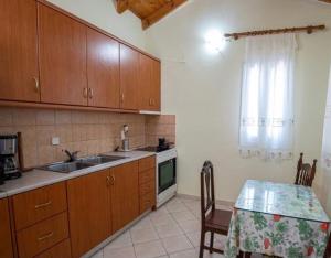 uma cozinha com um lavatório e uma mesa com uma mesa; em Private Cottage in Stavros em Marantochori