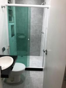 uma casa de banho com um WC e uma cabina de duche em vidro. em Lindo apartamento em Copacabana no Rio de Janeiro