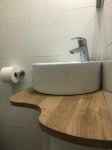 lavabo blanco en una encimera de madera en el baño en Le Studio Goëland, en Trouville-sur-Mer