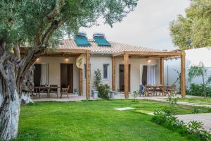 Ein Haus mit einer Terrasse mit einem Tisch und Stühlen in der Unterkunft Averta Rondo in Lefkada Town