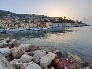 a group of rocks on the water with boats at Pilarella Gallery trilocale vistamare in Porto Santo Stefano