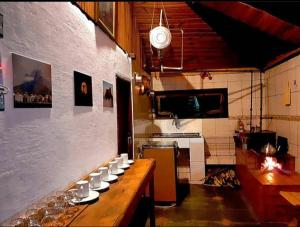 Chalés Horizonte Vertical في أيوريوكا: مطبخ مع طاولة مع كؤوس للنبيذ عليه