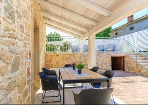 a patio with a wooden table and chairs at Pepe&Lynn in Višnjan