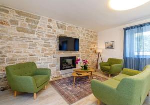 a living room with two chairs and a stone wall at Pepe&Lynn in Višnjan