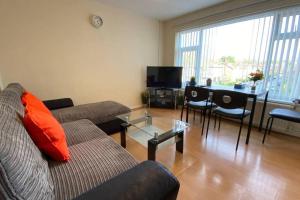 a living room with a couch and a table at Serene Apt in the Heart of Stretford in Manchester